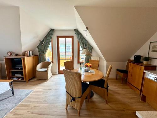 Una cocina y un comedor con mesa y sillas. en Oewern Diek App 08, en Wustrow