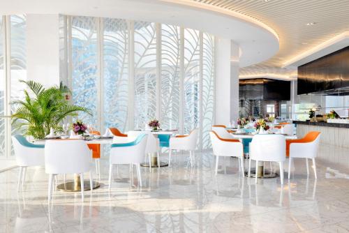 una sala da pranzo con tavoli, sedie e una parete di finestre di Palace Resort Yalong Bay Sanya a Sanya