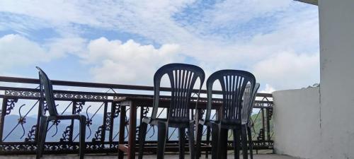 three chairs sitting at a table on a balcony at Nature Hike in Lansdowne