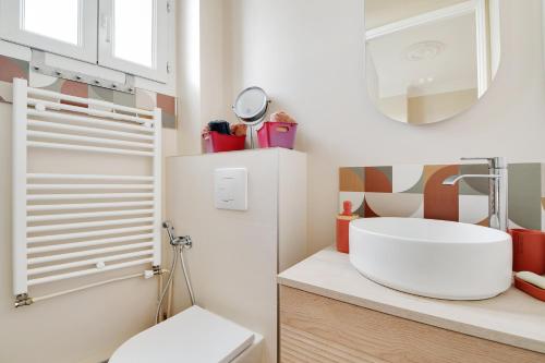une salle de bain avec un lavabo et des toilettes dans l'établissement Appartement Lumineux coeur de ville & proche Paris, à Vincennes