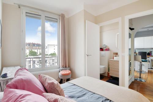 une chambre avec un lit et une grande fenêtre dans l'établissement Appartement Lumineux coeur de ville & proche Paris, à Vincennes