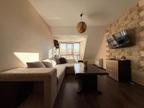 a living room with a couch and a tv at Home by the Sea MAIN STREET and POOL in Burgas