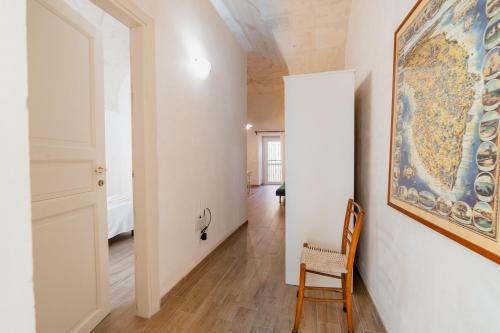 a room with a painting on the wall and a chair at CASA PAPADIA in Uggiano la Chiesa