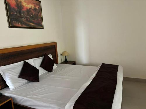 a bedroom with a white bed with black pillows at Nature Hike in Lansdowne