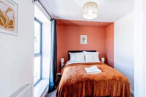 a small bedroom with orange walls and a bed at Luxury Retreat for 10 with Hot Tub and Spacious Garden in Manchester