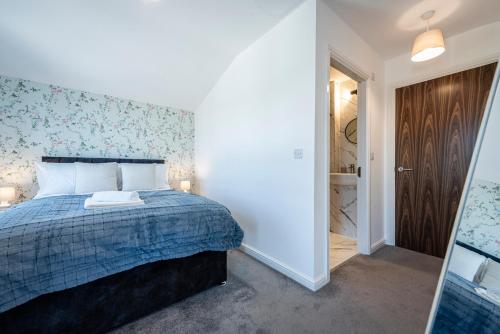 a bedroom with a bed and a walk in shower at Luxury Retreat for 10 with Hot Tub and Spacious Garden in Manchester
