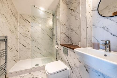 a white bathroom with a sink and a toilet at Luxury Retreat for 10 with Hot Tub and Spacious Garden in Manchester