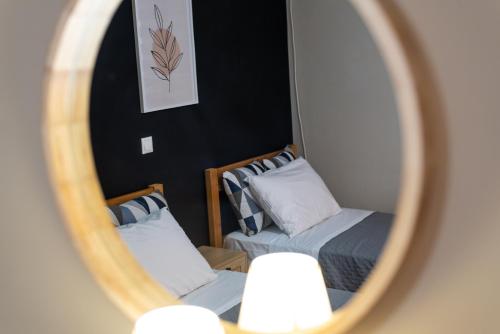 two beds in a room with a mirror at DreamCoast Apartments I in Artemida