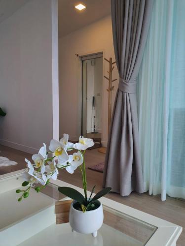 a room with a vase with white flowers on a table at ม่อนเหนือโฮมสเตย์ Monnuea Homestay in Mon Jam