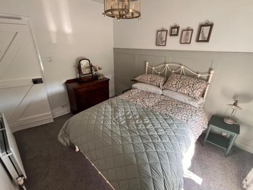 ein Schlafzimmer mit einem Bett, einem Tisch und einer Uhr in der Unterkunft Fiddlers Cottage in Springmount