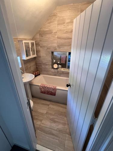 a bathroom with a tub and a sink at Fiddlers Cottage in Springmount