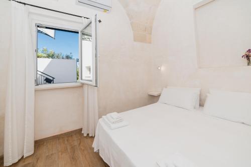 a bedroom with a white bed and a window at CASA PAPADIA in Uggiano la Chiesa