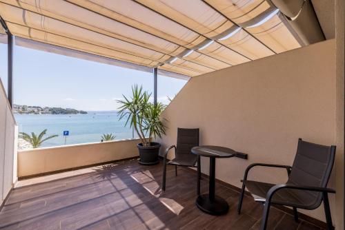 a room with a table and chairs and a view of the ocean at Sea View Luxury Rooms Seven of Nine in Split