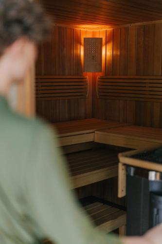 a person in a sauna with a light in it at Zur Margarethenmühle - Landgasthof und Waldhotel in Döbeln