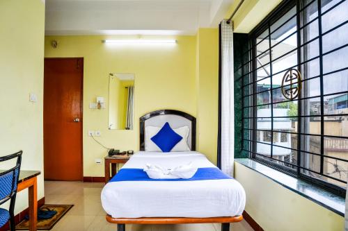 a bedroom with a bed and a large window at HOTEL NILADRII GALAXY in Siliguri