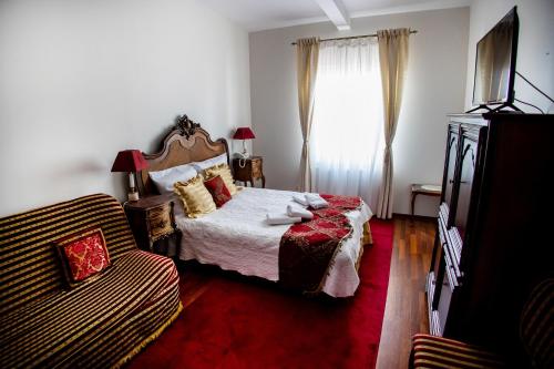 a bedroom with a bed and a couch and a window at Hotel Napoleon in Wróblew