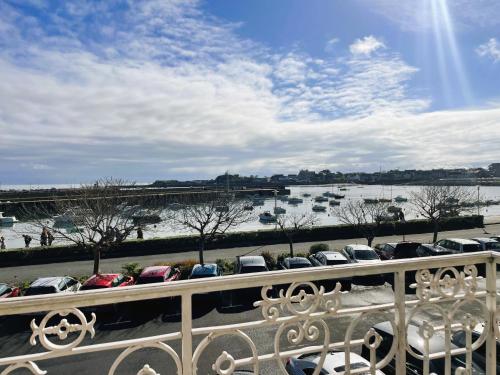 a row of cars parked in a parking lot next to a river at La Maison du Port, vue mer, jardin et parking in Roscoff