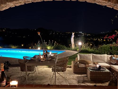 un patio avec une table et un canapé la nuit dans l'établissement Sea View Villa in the French Riviera, à La Colle-sur-Loup