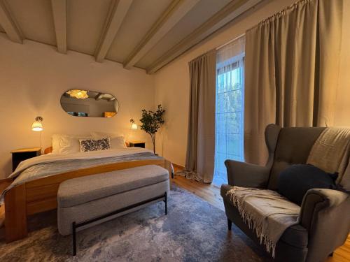 a bedroom with a bed and a couch and a window at Villa Wejsunka in Wejsuny