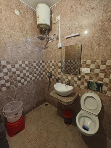 a bathroom with a toilet and a sink at Ghai's Sunrise Homestay in Mussoorie
