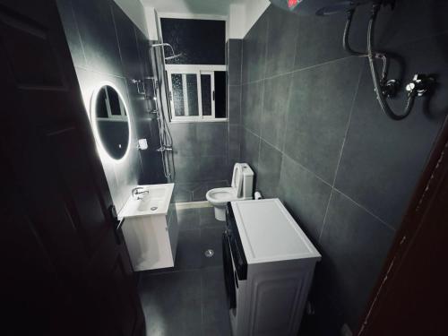 a small bathroom with a sink and a toilet at Kiart's by Sea Apartment in Golem