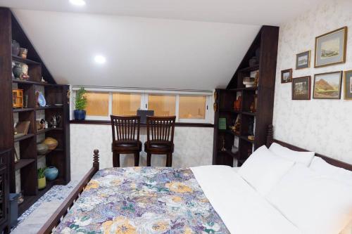 a bedroom with a bed and two chairs and a window at The Rustic Home - Nguyên căn in Ho Chi Minh City