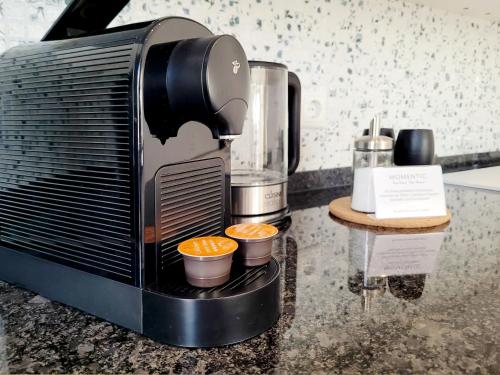 a coffee maker with two cups of oranges at Hafenromantik pur - Exklusive Ferienwohnung mit erstklassigem Blick von "Momentic" in Neustadt in Holstein