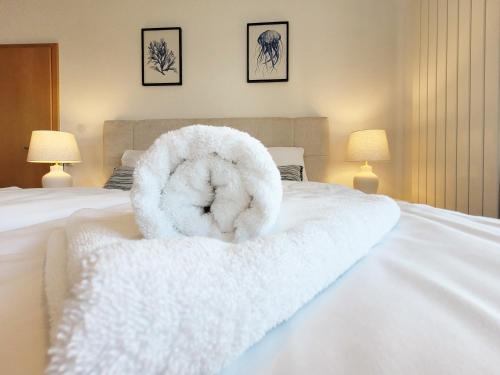 a white towel animal sitting on top of a bed at Hafenromantik pur - Exklusive Ferienwohnung mit erstklassigem Blick von "Momentic" in Neustadt in Holstein