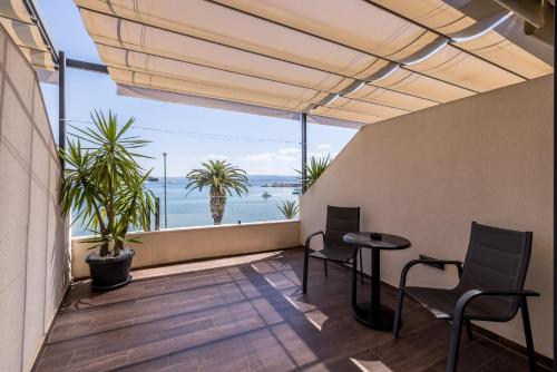 a balcony with a table and chairs and a view of the ocean at Sea View Luxury Rooms Seven of Nine in Split