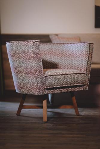 a chair with a cat sleeping in it at Hotel DIE SONNE in Saalbach Hinterglemm