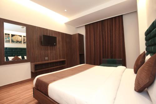 a hotel room with a bed and a television at Park Plaza Hotel Near Golden Temple in Amritsar