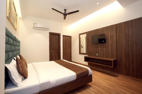 a bedroom with a bed and a flat screen tv at Park Plaza Hotel Near Golden Temple in Amritsar