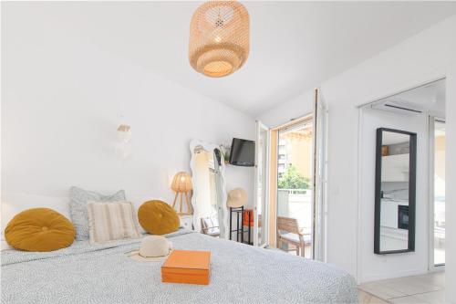 - une chambre blanche avec un lit et une couverture bleue dans l'établissement PIERRE DE GEMMES - Agréable deux pièces - Menton - Parking Gratuit, à Menton