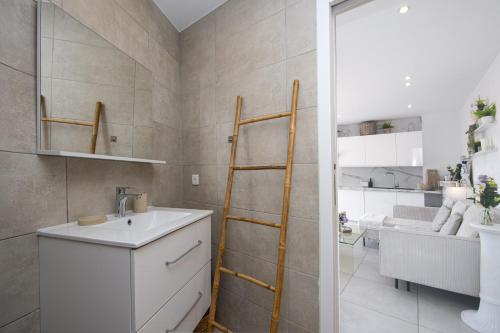 une salle de bain avec un lavabo et un miroir dans l'établissement PIERRE DE GEMMES - Agréable deux pièces - Menton - Parking Gratuit, à Menton