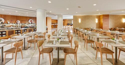 a dining room with white tables and chairs at Sercotel Sorolla Palace in Valencia