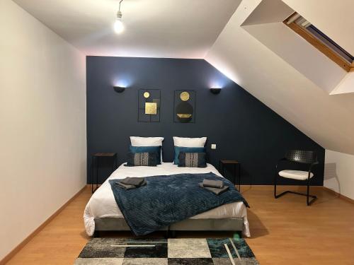 une chambre avec un lit et un mur bleu dans l'établissement L Ervélégance - Jardin DS - L'Harmonie Evénements House, à Sablé-sur-Sarthe