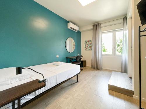 a bedroom with a bed and a blue wall at RRRapido Colorful Rooms - Assago in Assago