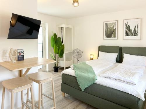 a bedroom with a bed and a table and a desk at Neues Küstenjuwel mit erstklassiger Einrichtung direkt am Hafen "Momentic" in Neustadt in Holstein