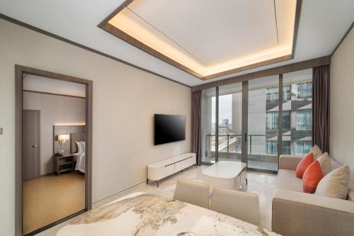 a living room with a couch and a tv at HARRIS Hotel & Suites Nagoya Batam in Nagoya