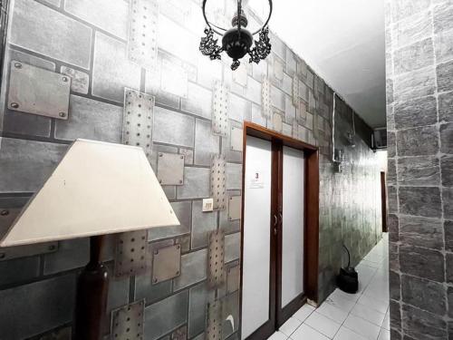 a lamp in a hallway with a brick wall at Modom Residence in Jakarta