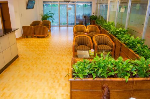 a waiting room with chairs and plants at Laurel Hotel Lake View in Dhaka
