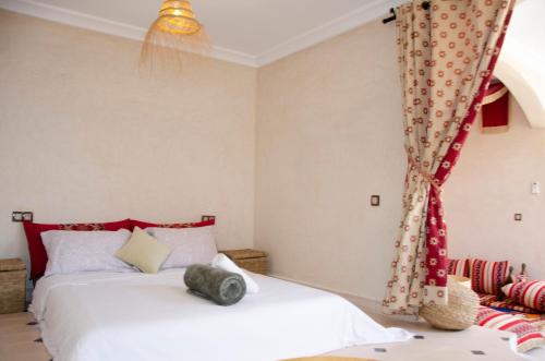 a bedroom with two beds and a curtain at SurfAppart Morocco in Tamraght Ouzdar