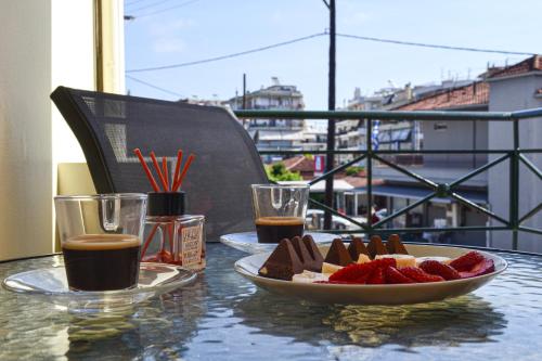 a table with a plate of food and a plate of strawberries at Casa Dio in Preveza