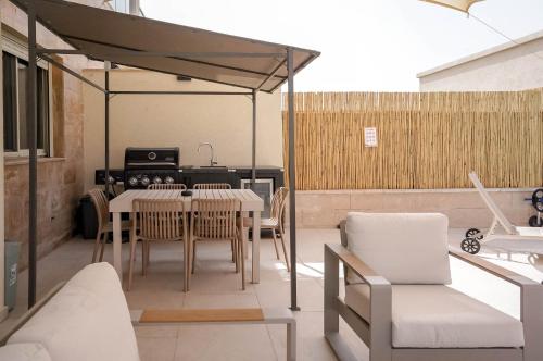 a patio with a table and chairs and a kitchen at YalaRent Eilat Villa 4BR Private Pool & Garden in Eilat