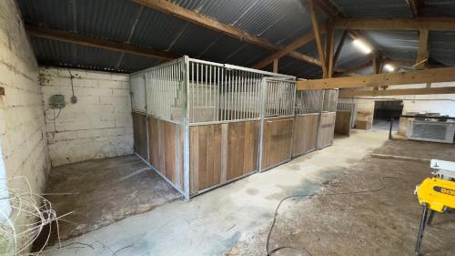 an empty barn with a horse stalls in it at La ferme Le Clos de la Becque in Muncq-Nieurlet