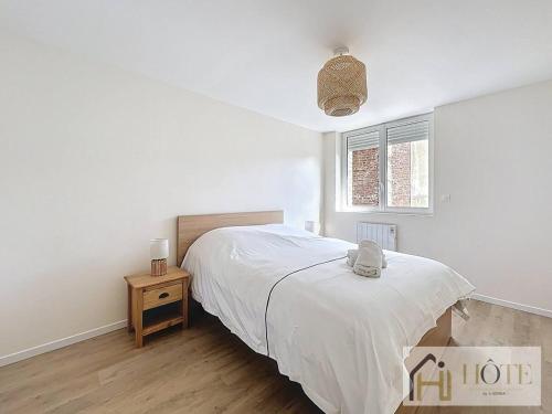 - une chambre blanche avec un lit et une table de nuit dans l'établissement Le Nid Moderne - Spacieux 2 Ch, à Dunkerque