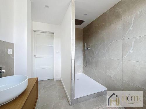 une salle de bain avec un lavabo blanc et une douche dans l'établissement Le Nid Moderne - Spacieux 2 Ch, à Dunkerque