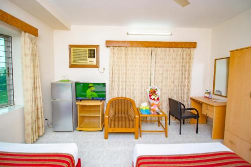 a living room with a television and a table and chairs at Laurel Hotel Lake View in Dhaka