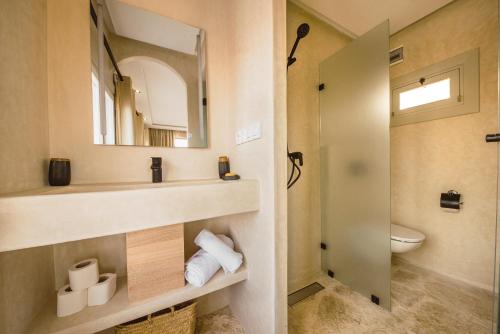 a bathroom with a sink and a toilet and a mirror at New Spirit Dakhla in Dakhla