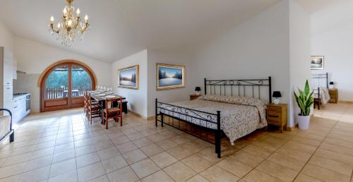 a bedroom with a bed and a table and a kitchen at Podere Santo Signoretto in San Vincenzo